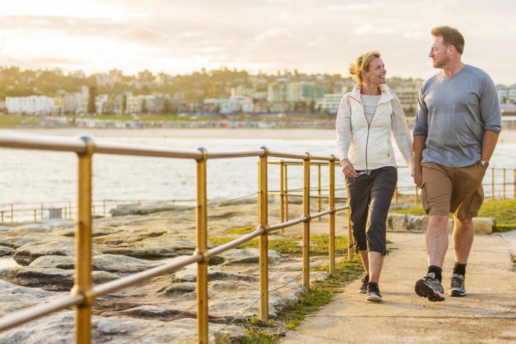 Man and woman enjoying seaside walk, reflecting improved wellbeing and long-term health from bariatric surgery support